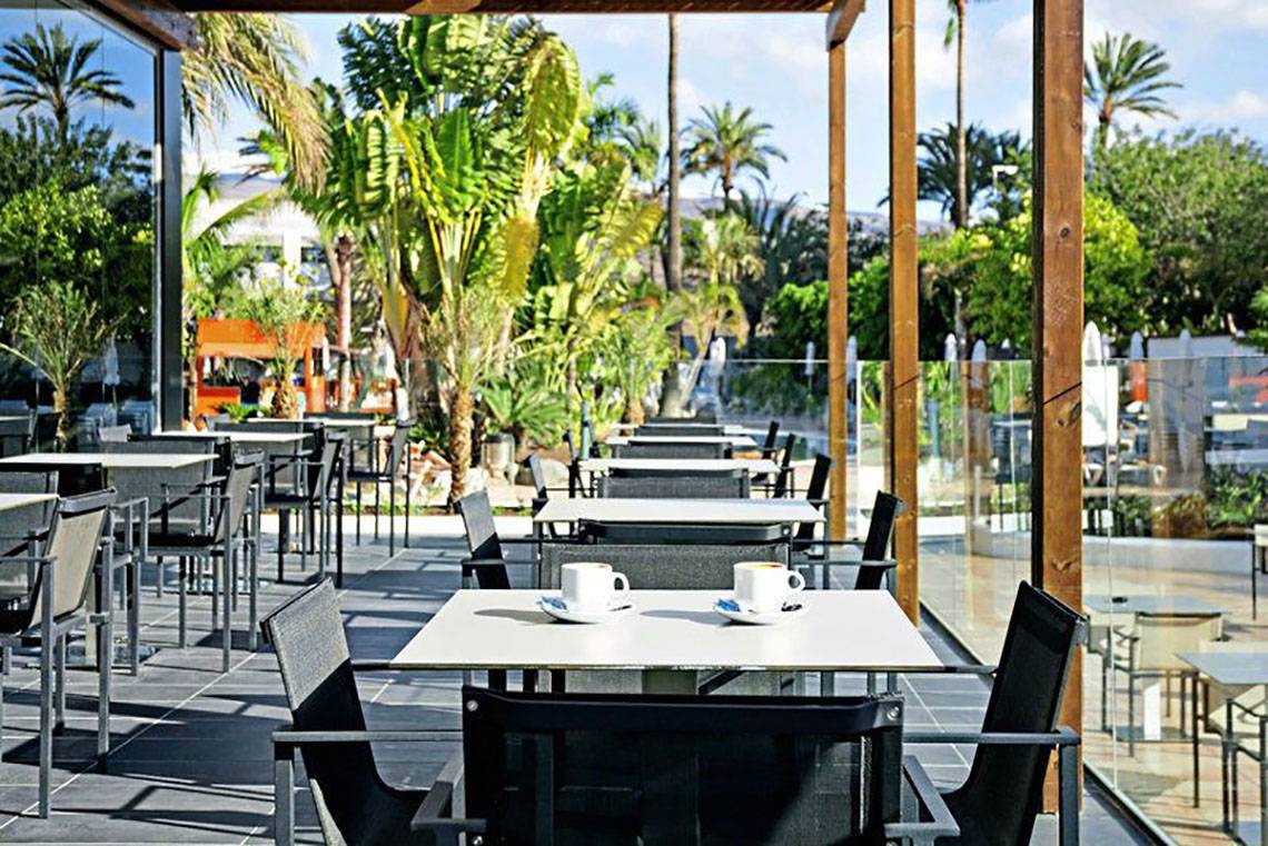 Außenbereich des Gran Canaria Princess Hotels mit vielen Tischen und Stühlen im Freien.
