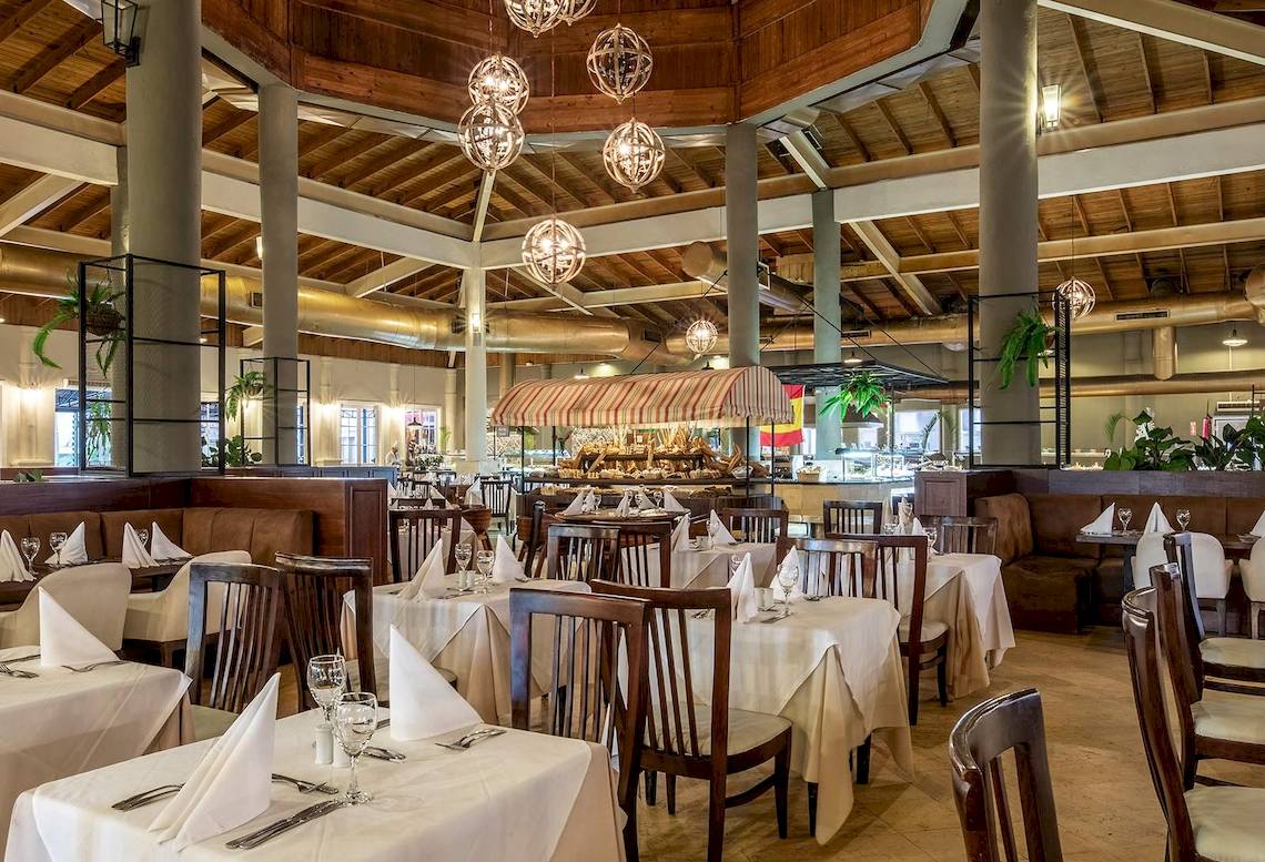 Innenbereich eines Restaurants im Sunscape Coco Punta Cana Hotel mit gedeckten Tischen und Stühlen.