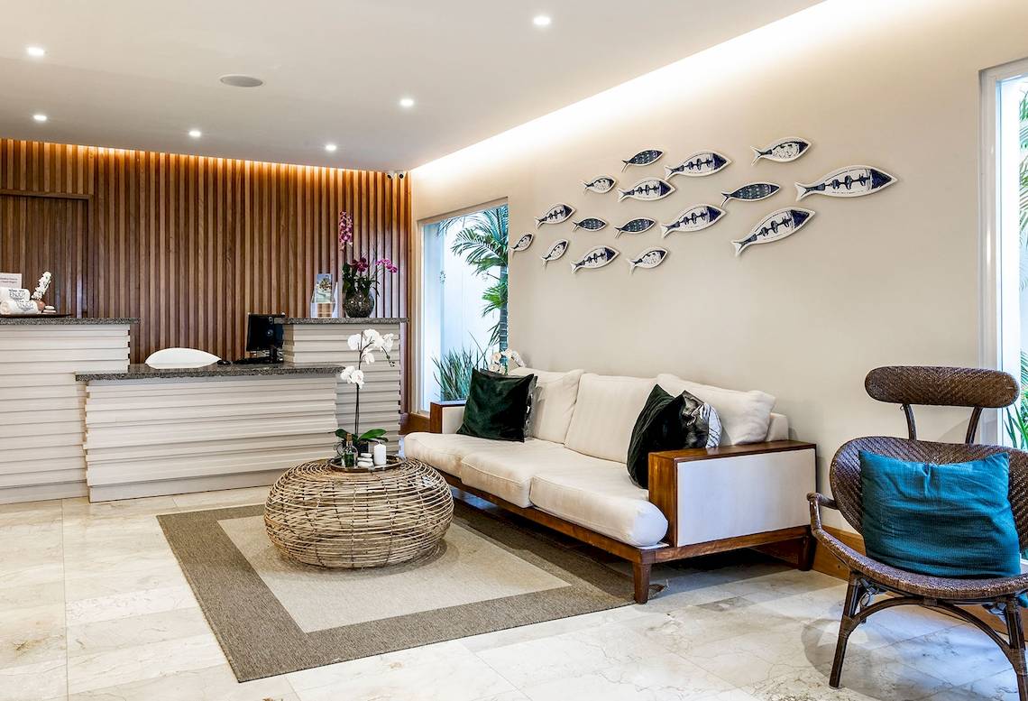 Empfangsbereich des Sunscape Coco Punta Cana Hotels mit weißem Sofa, Tisch und Dekorationen.