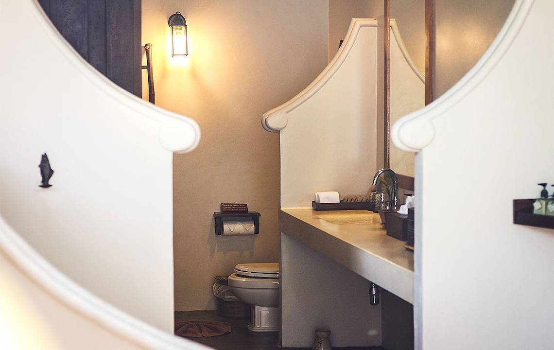 Ein Badezimmer im Saree Samui Resort mit einer Toilette, einem Waschbecken und einer Lampe.