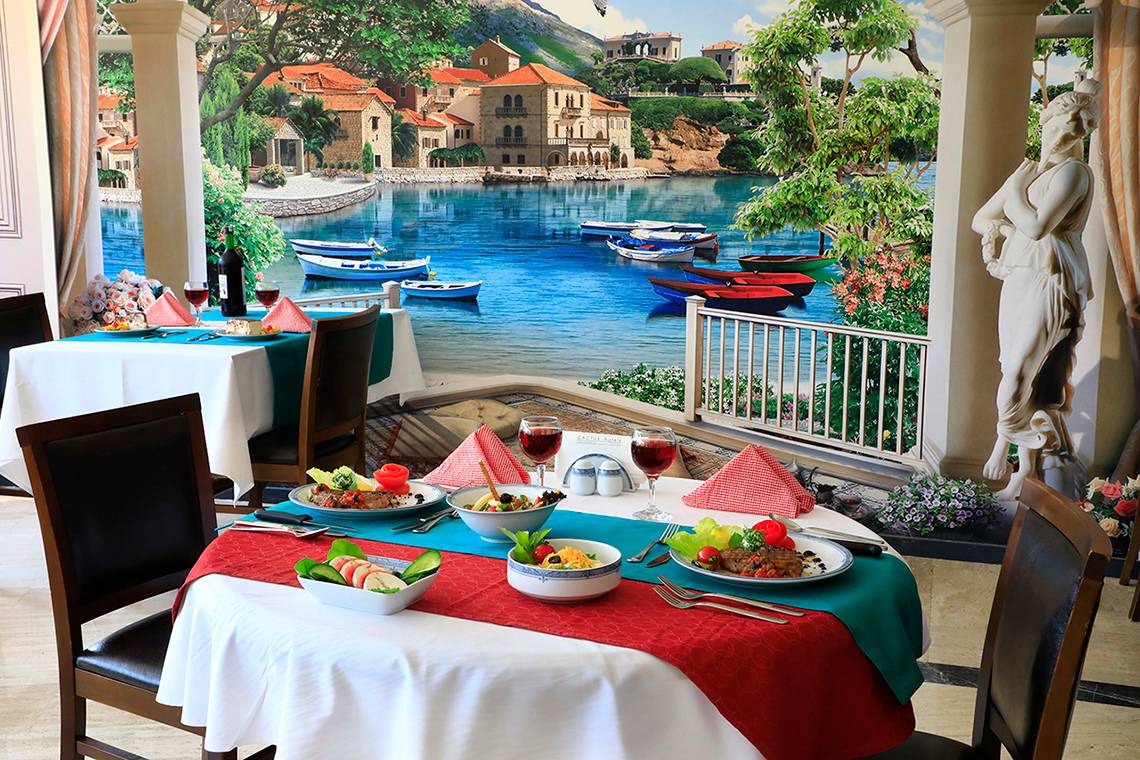 Im Club Yali Hotels & Resort Restaurant steht ein Tisch mit Essen und Meerblick.