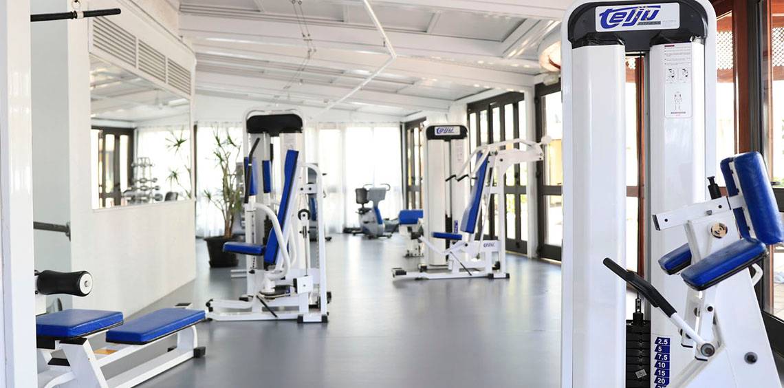 Fitnesscenter im Corallium Dunamar Garden Hotel mit verschiedenen Trainingsgeräten und Spiegeln