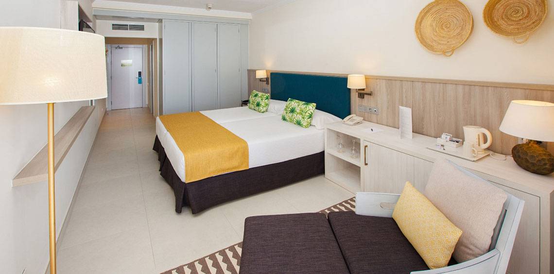 Doppelzimmer im Corallium Dunamar Garden by Lopesan Hotels mit Bett, Lampen, Nachttischen und Dekor.