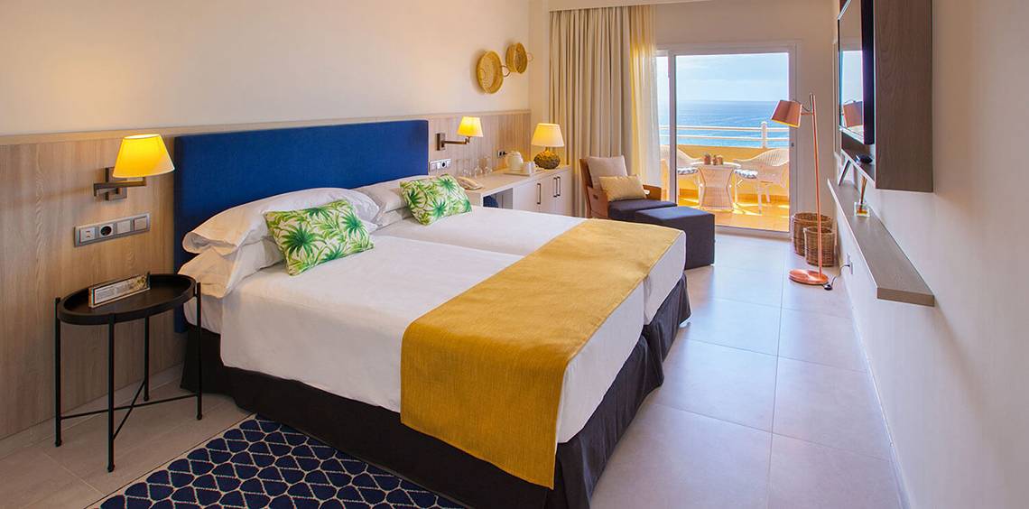 Doppelzimmer mit Meerblick im Corallium Dunamar Garden by Lopesan Hotels, mit zwei Betten, einem Nachttisch und einem Balkon.