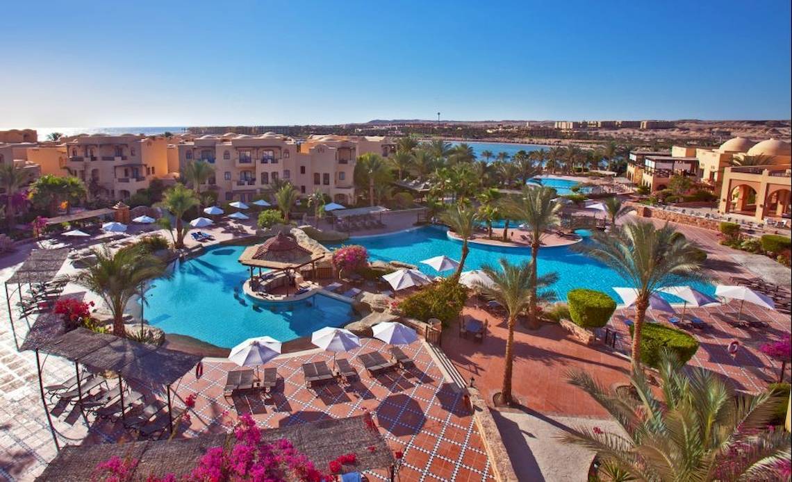 Aussenbereich des Steigenberger Coraya Beach Hotels mit Swimmingpool und Sonnenliegen.