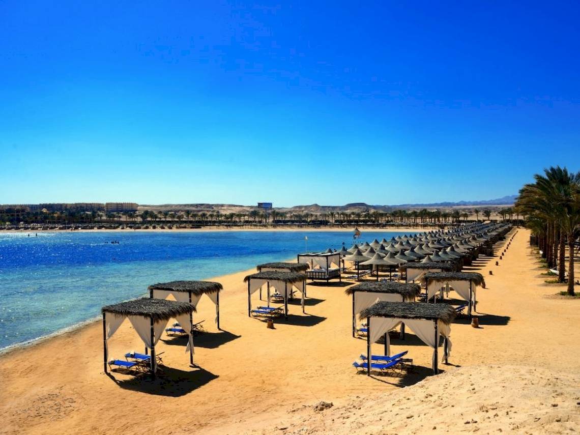Strand des Steigenberger Coraya Beach Hotels mit vielen Sonnenschirmen und Liegen