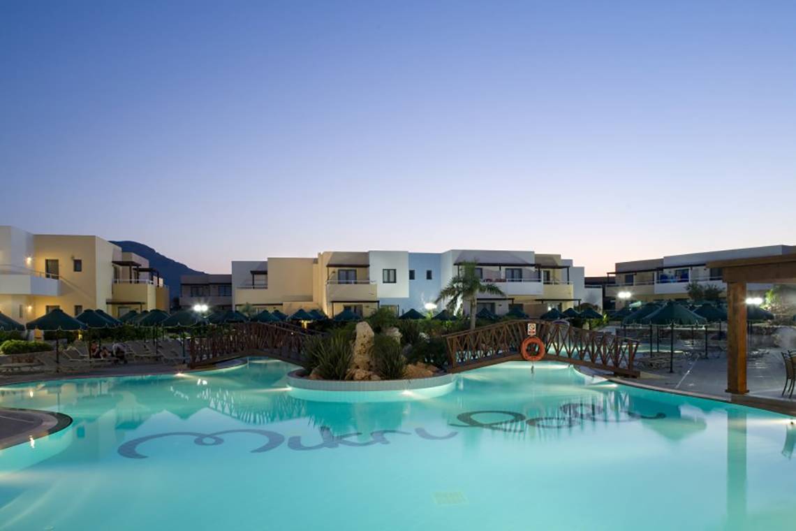 Außenansicht des Swimmingpools im Atlantica Mikri Poli Hotel auf Rhodos bei Sonnenuntergang.