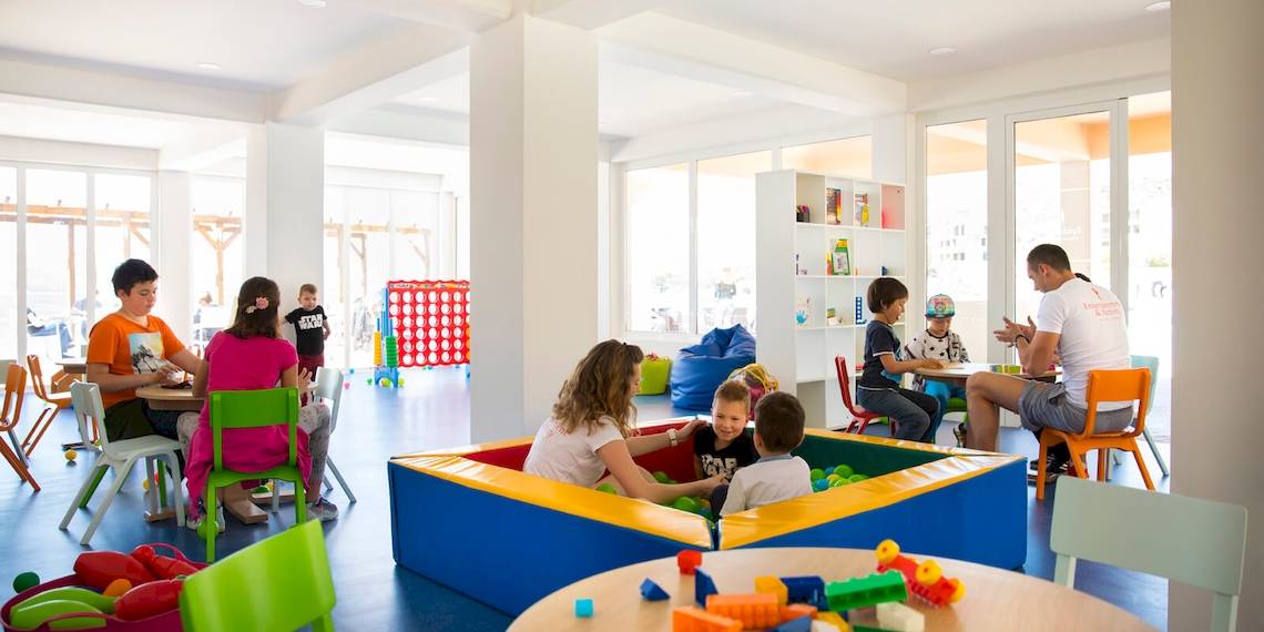 Familien und Kinder spielen in einem farbenfrohen Spielbereich im Remisens Hotel Epidaurus.