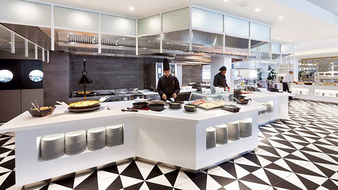 Restaurant-Innenbereich des Hotels Tigotan Lovers & Friends mit schwarzen und weißen Bodenfliesen und weißen Tischen.