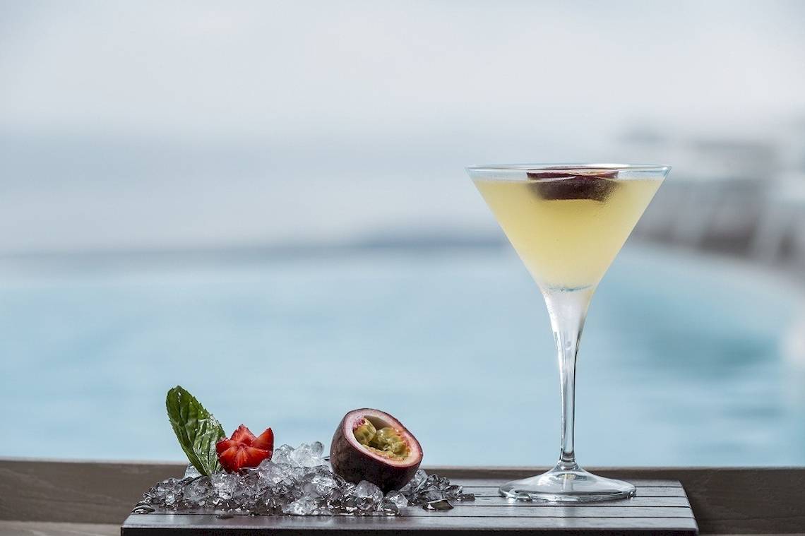 Cocktail auf einer Eisschale mit Früchten neben dem Pool im Katikies Chromata Santorini