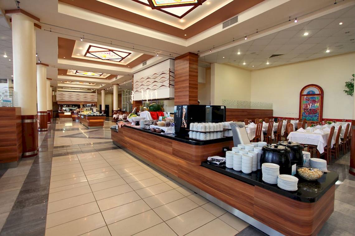 Innenbereich des DIT Evrika Beach Club Hotels mit Buffet und Sitzbereichen.