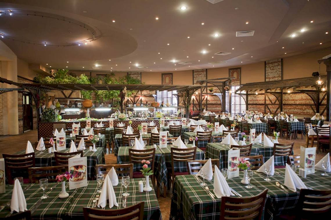 Innenansicht des DIT Evrika Beach Club Restaurants mit gedeckten Tischen und Stühlen.