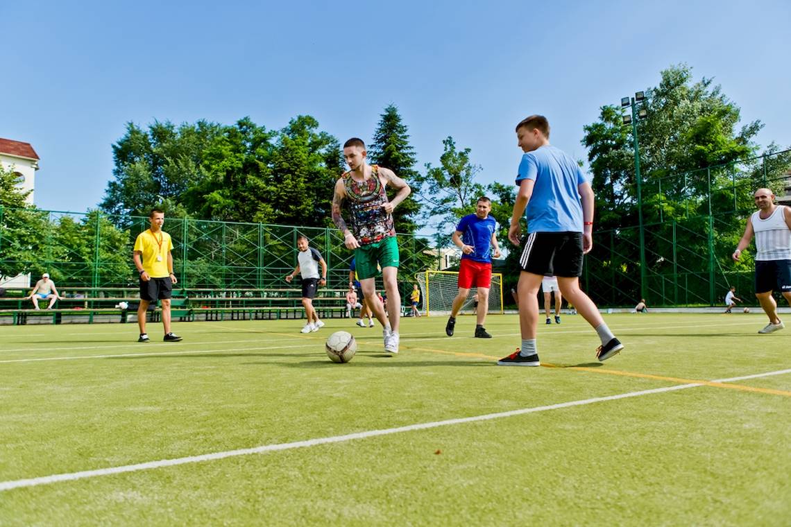 Fussballmannschaft des DIT Evrika Beach Club spielt auf einem Kunstrasenplatz im Freien.