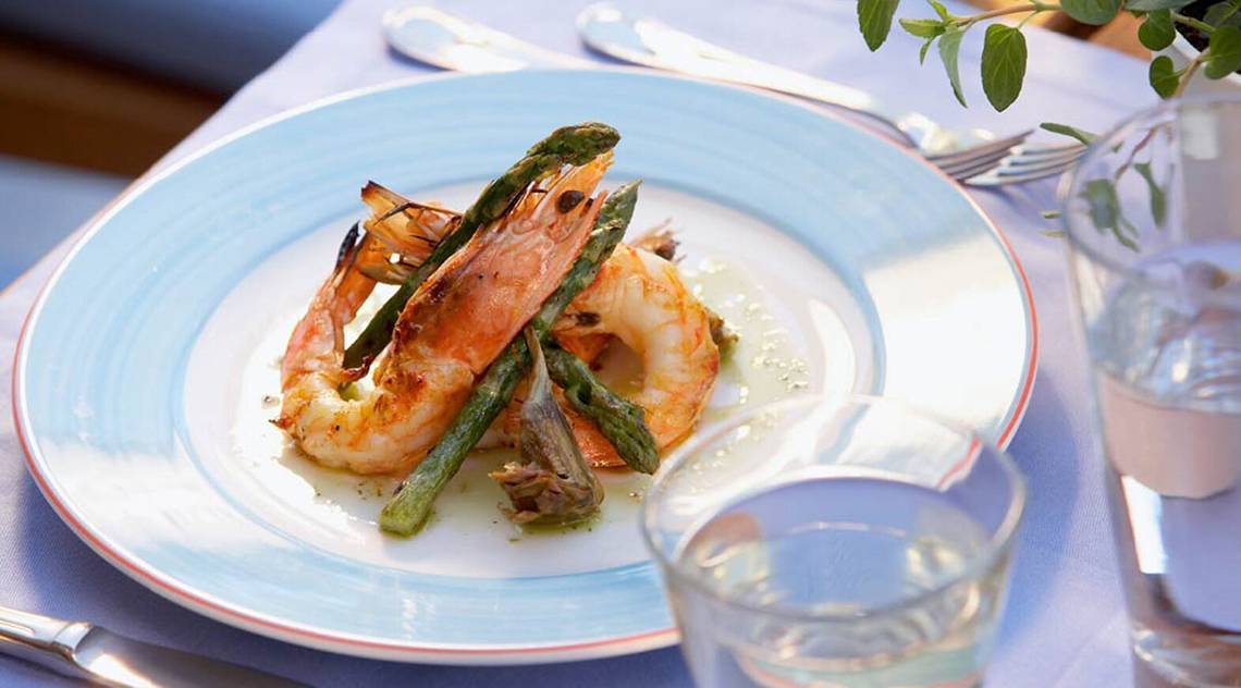 Gerichteteller mit Garnelen und Spargel im Daios Cove Luxury Resort & Villas