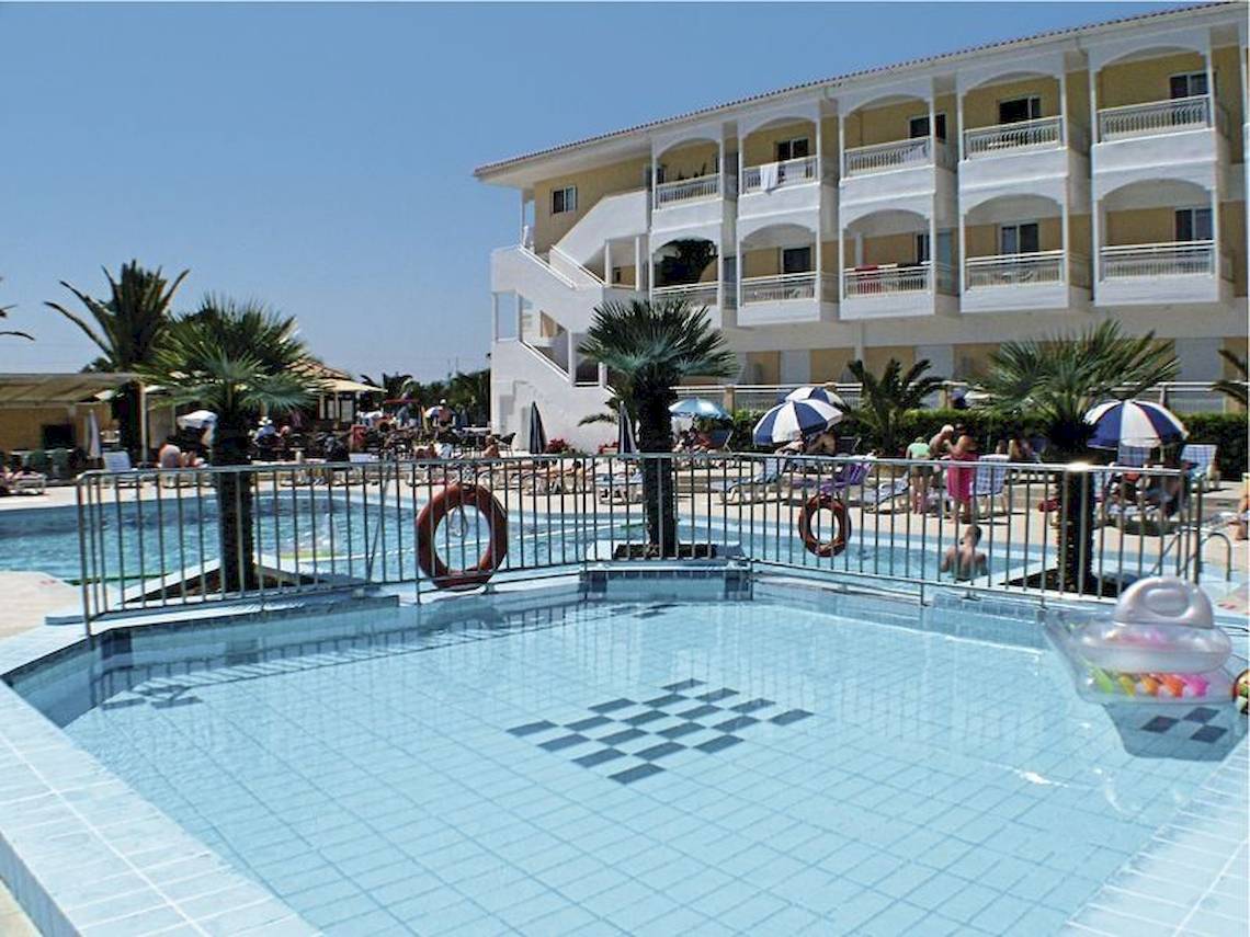 Schwimmbadbereich des Poseidon Beach Hotels mit Gebäuden, Palmen und Gästen