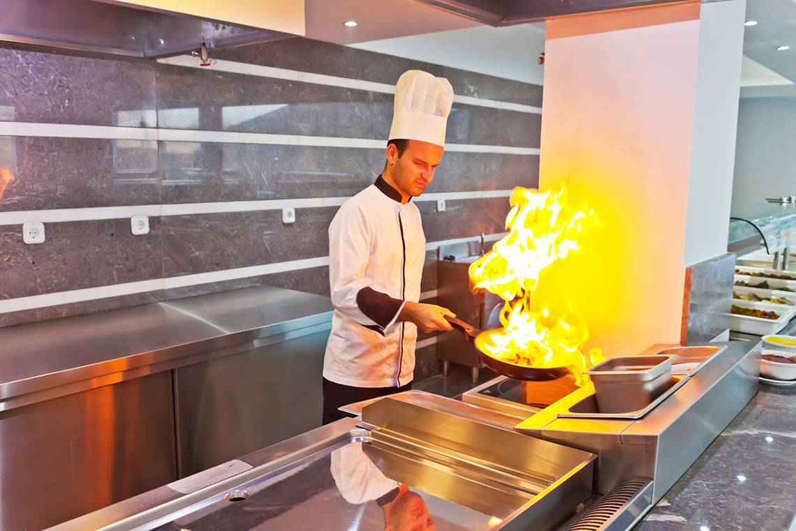 Koch mit Feuer in der Küche des Royal Marmin Bay Boutique Hotels