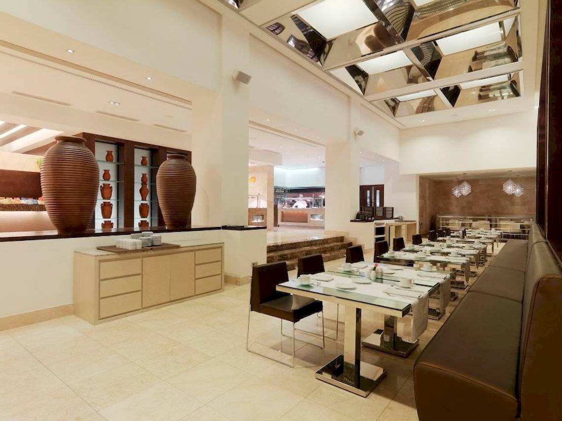 Innenansicht des Restaurants im Gran Melia Palacio de Isora Hotel mit runden Vasen und gefliestem Boden.