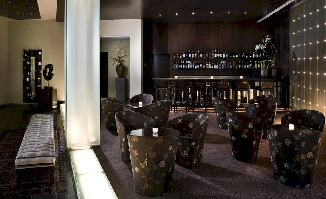 Hotellounge des Gran Melia Palacio de Isora mit dekorierten Stühlen und einer Bar.