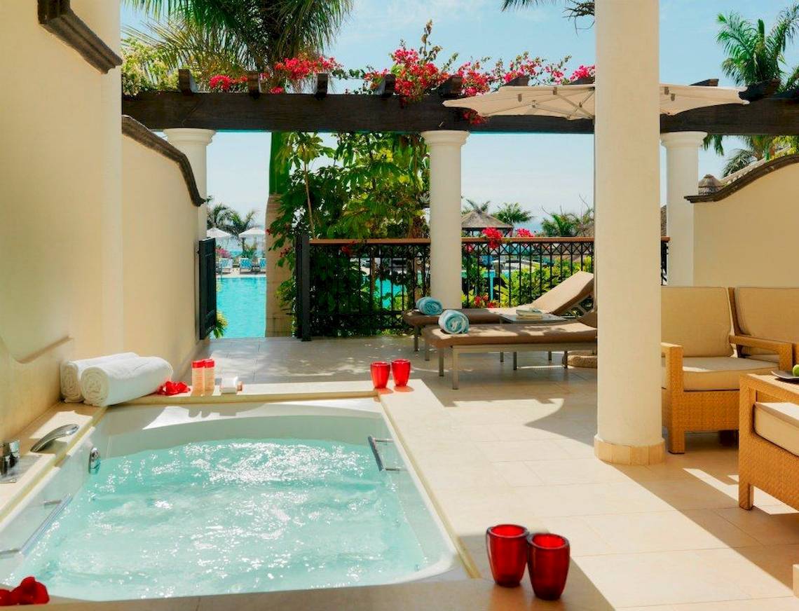 Terrasse des Gran Melia Palacio de Isora Hotels mit Whirlpool und Blick auf den Pool.