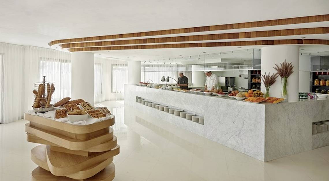 Frühstücksbuffet im Hyatt Place Taghazout Bay Hotel mit verschiedenen Gerichten und zwei Köchen im Hintergrund.
