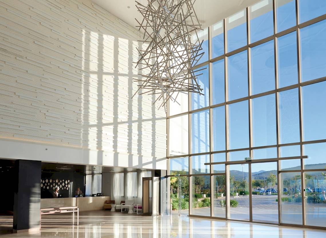 Lobby des Hyatt Place Taghazout Bay Hotels mit großen Fenstern und moderner Einrichtung.