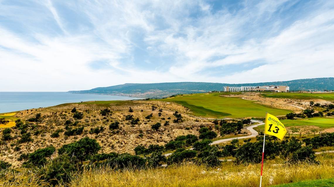 Golfplatz mit Blick auf das Meer und das Hyatt Place Taghazout Bay Hotel in der Ferne.