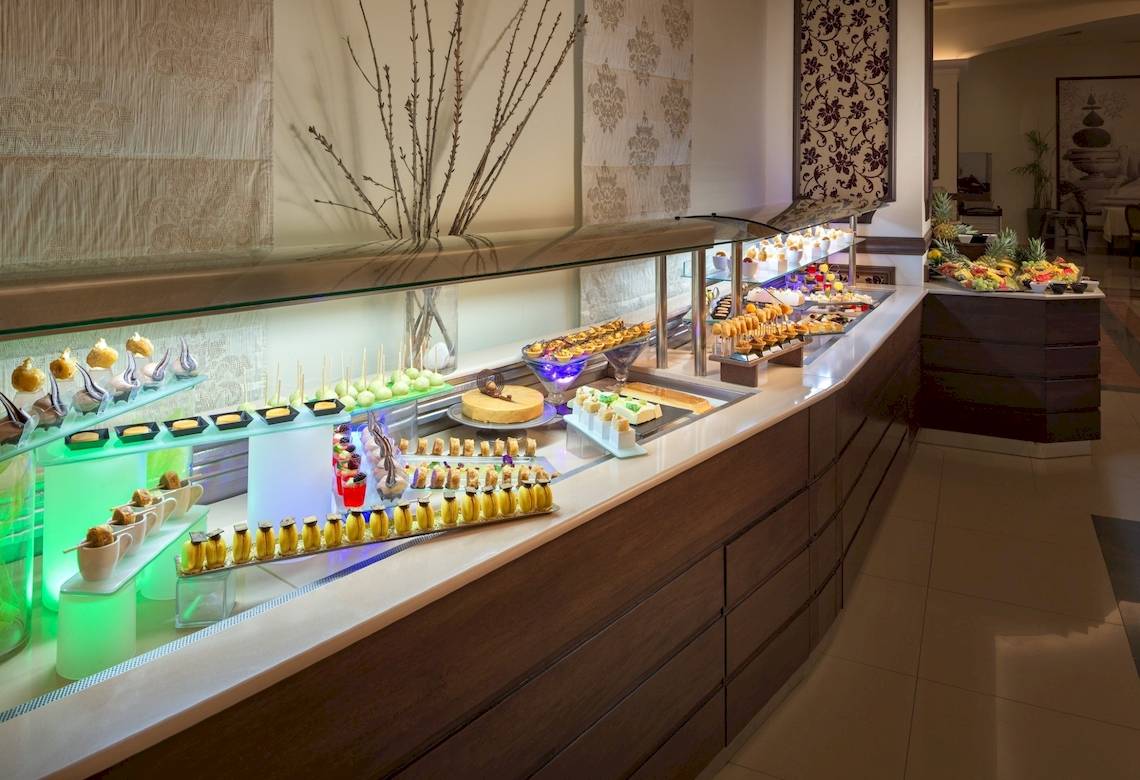 Buffet im La Marquise Luxury Resort Complex mit verschiedenen Desserts und Früchten.