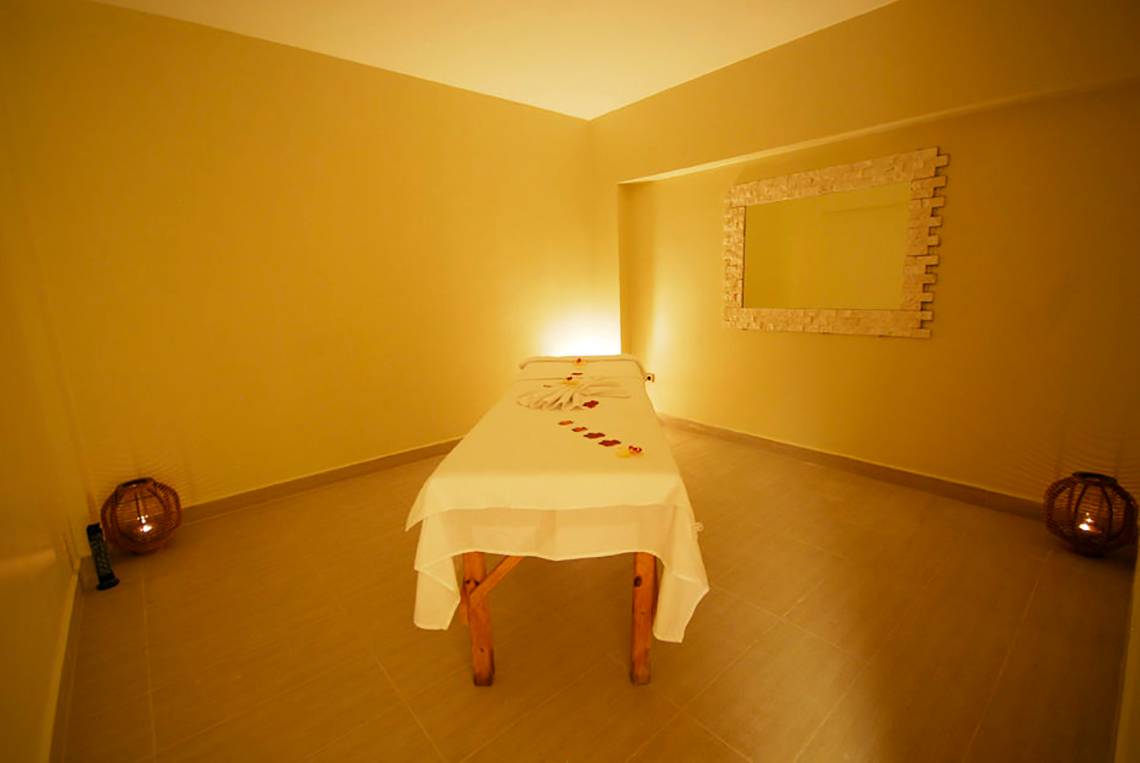 Massageraum im Meril Hotel mit einer Behandlungsliege, Kerzen und einem Spiegel
