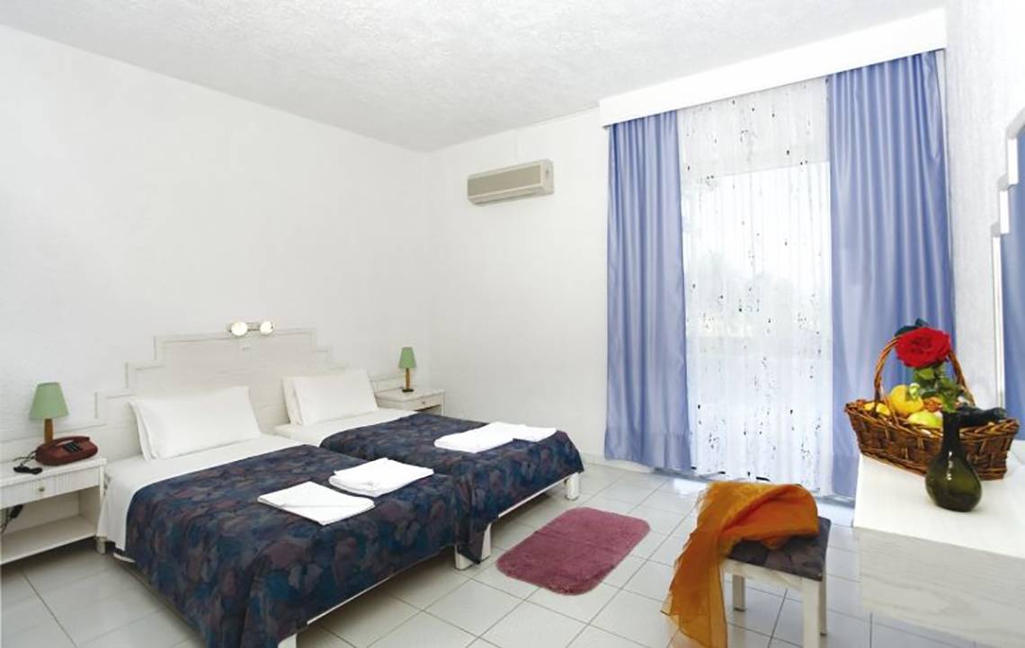 Doppelbettzimmer im Golden Star Hotel auf Kos mit frischen Handtüchern und Obstkorb.