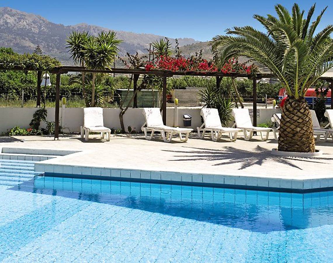 Außenpool des Golden Star Hotels mit Liegestühlen und Palmen im Hintergrund.