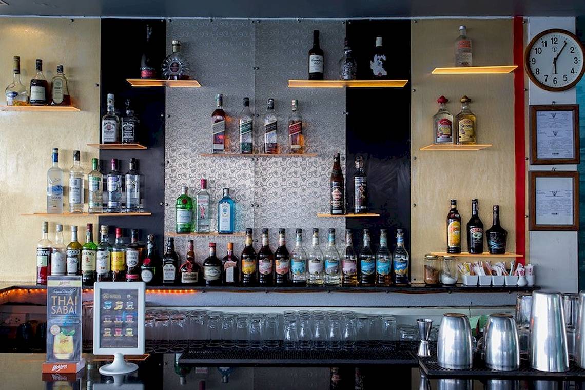 Eine Bar mit vielen alkoholischen Getränkeflaschen und Gläsern.