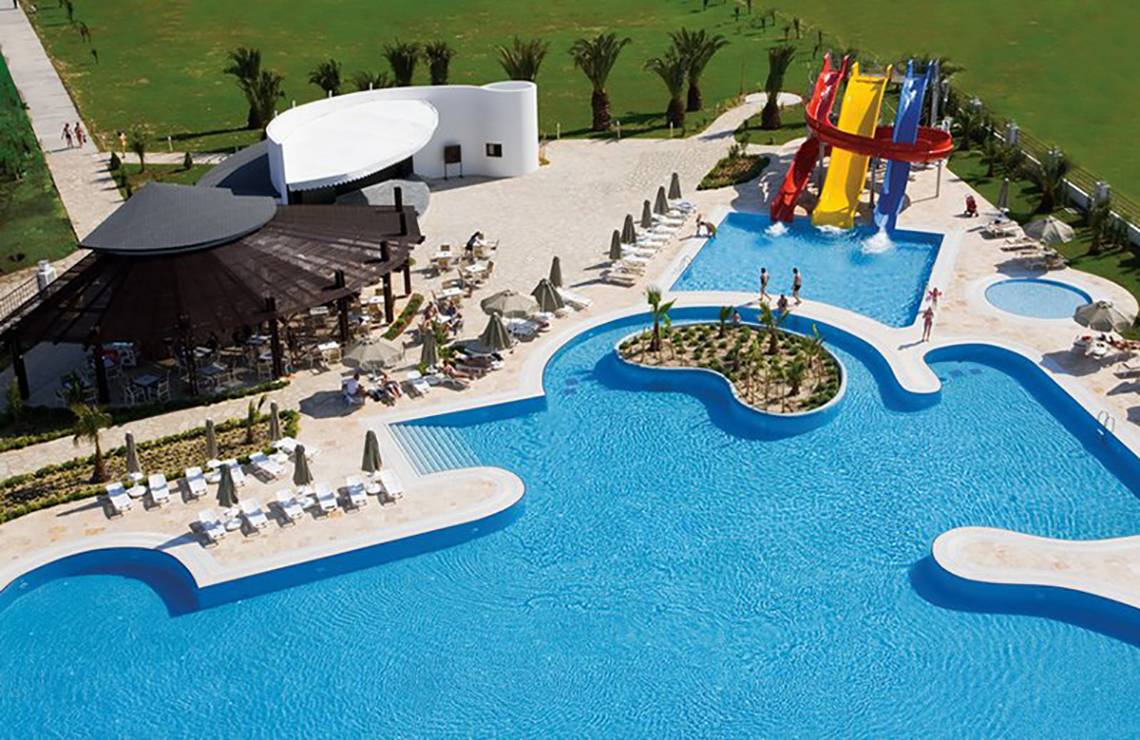 Luftaufnahme des Melas Lara Hotels mit Pool, Wasserrutschen und Sonnenliegen