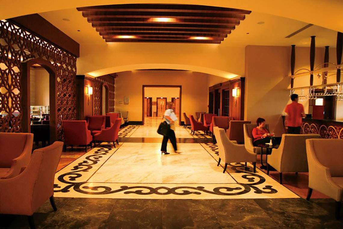 Hotellobby des Melas Lara Hotels mit geometrischem Muster auf dem Boden und Sitzbereichen.