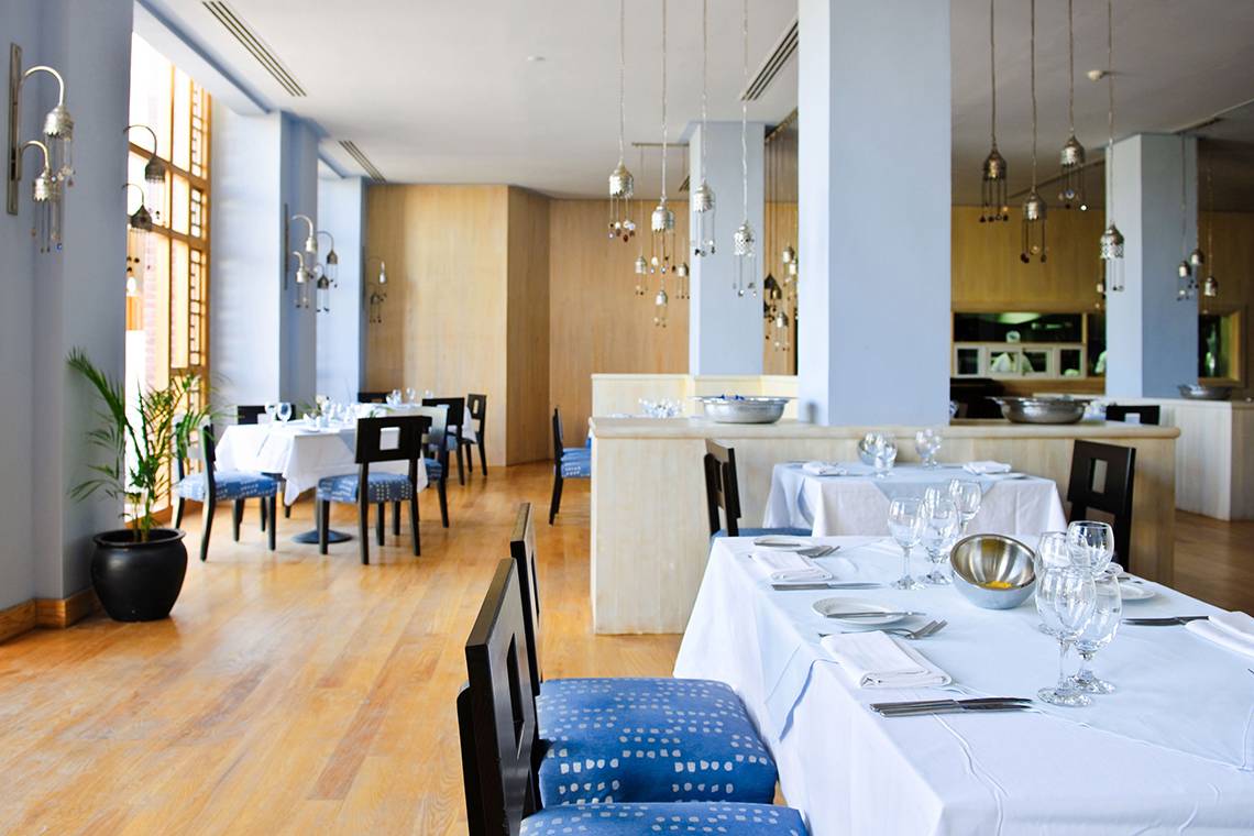 Innenansicht eines Restaurants im Grand Hotel Sharm El Sheikh mit gedeckten Tischen und Stühlen.