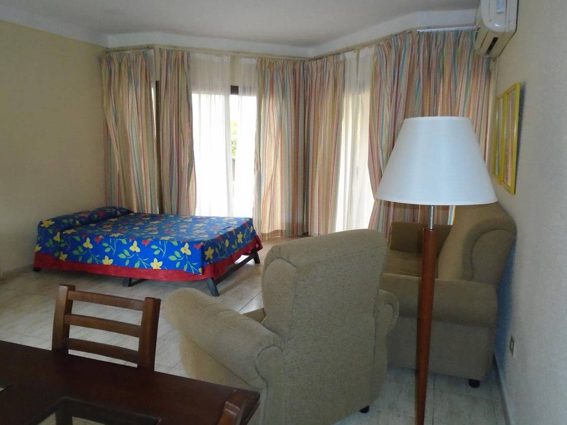 Hotelzimmer im ROC Arenas Doradas mit Bett, Stühlen, Tisch und Lampe.