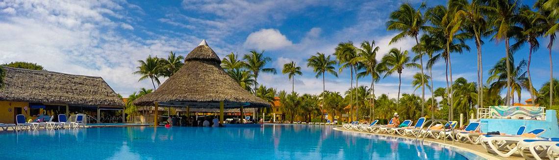 Außenpool des ROC Arenas Doradas Hotels mit Palmen und Sonnenliegen.