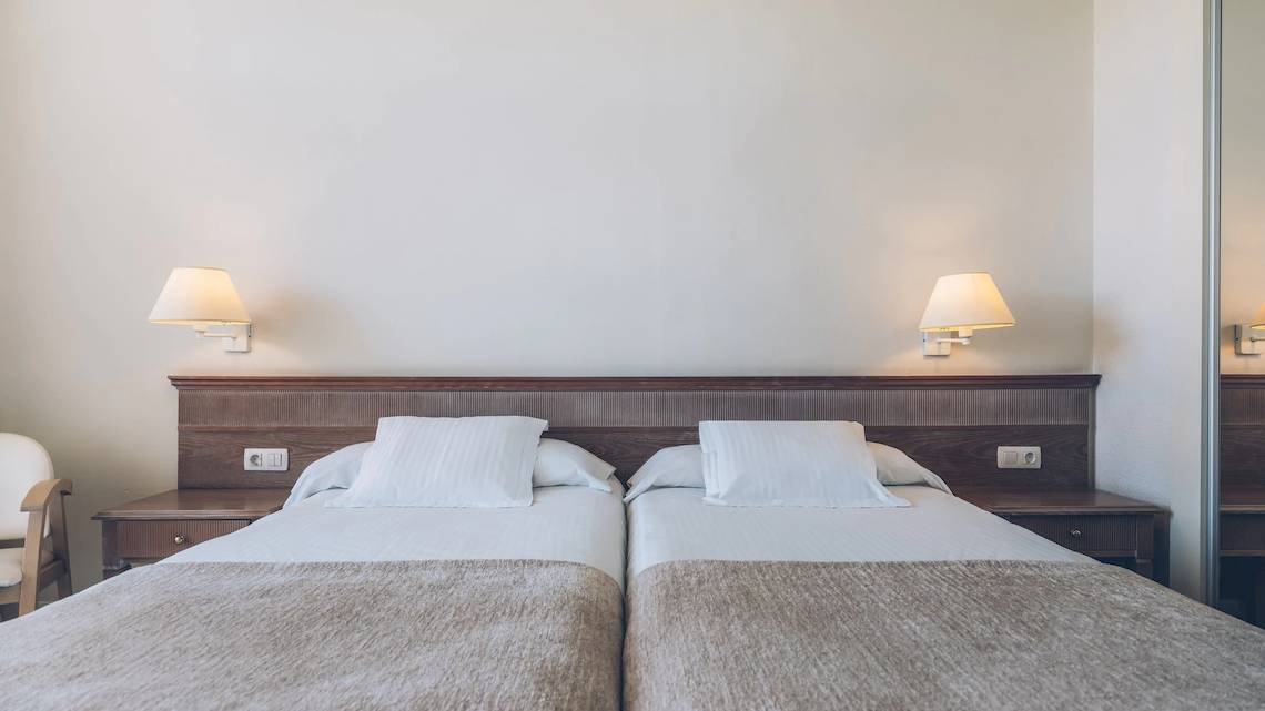 Doppelbettzimmer im Iberostar Las Dalias Hotel mit weißen Laken und Kissen.
