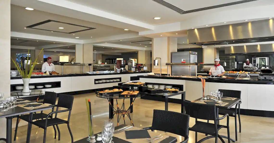 Restaurant im Sol Barbados Hotel mit Angestellten, die Essen zubereiten und servieren.