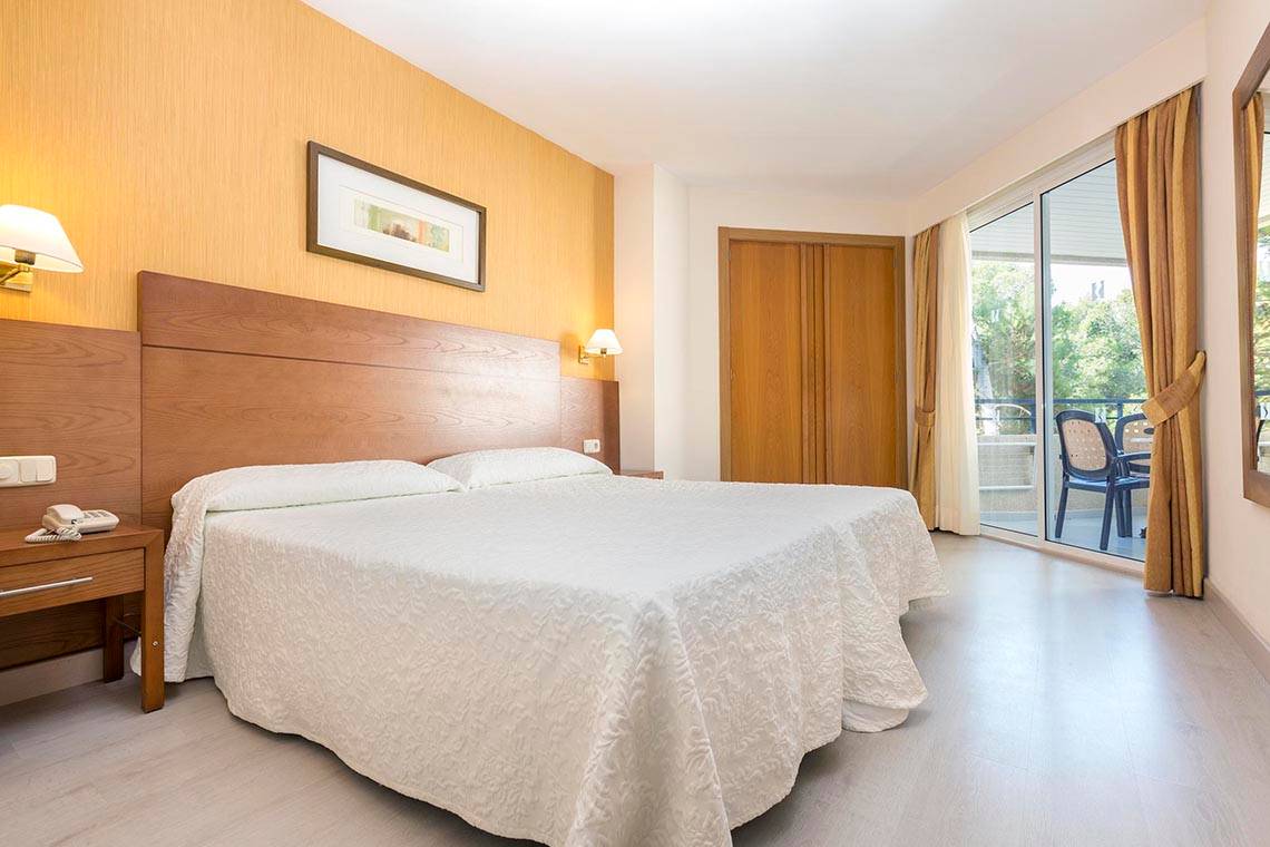 Ein Hotelzimmer im Hipotels Bahia Grande mit zwei Betten, einer Kommode und einem Telefon.