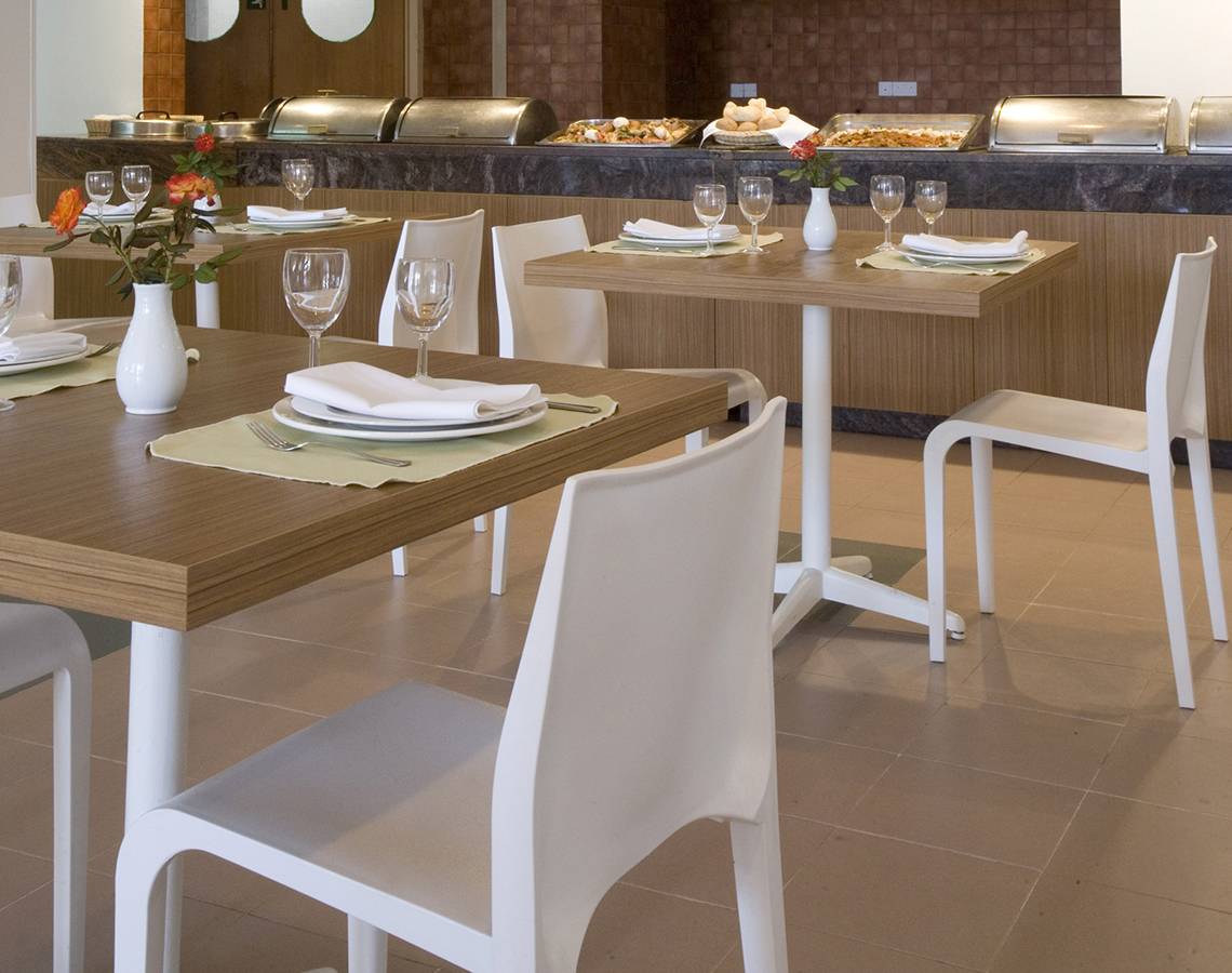 Innenbereich des Venus Beach Hotels mit Restauranttisch und Blumen