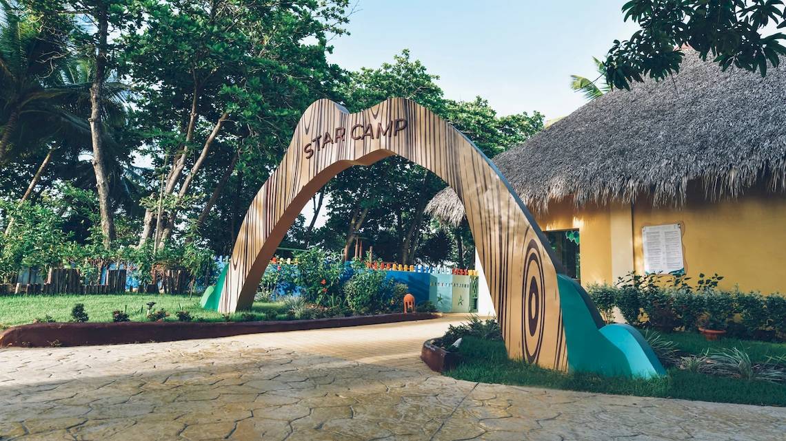 Eingang des Iberostar Costa Dorada Hotels mit einem bogenförmigen Star Camp Schild.