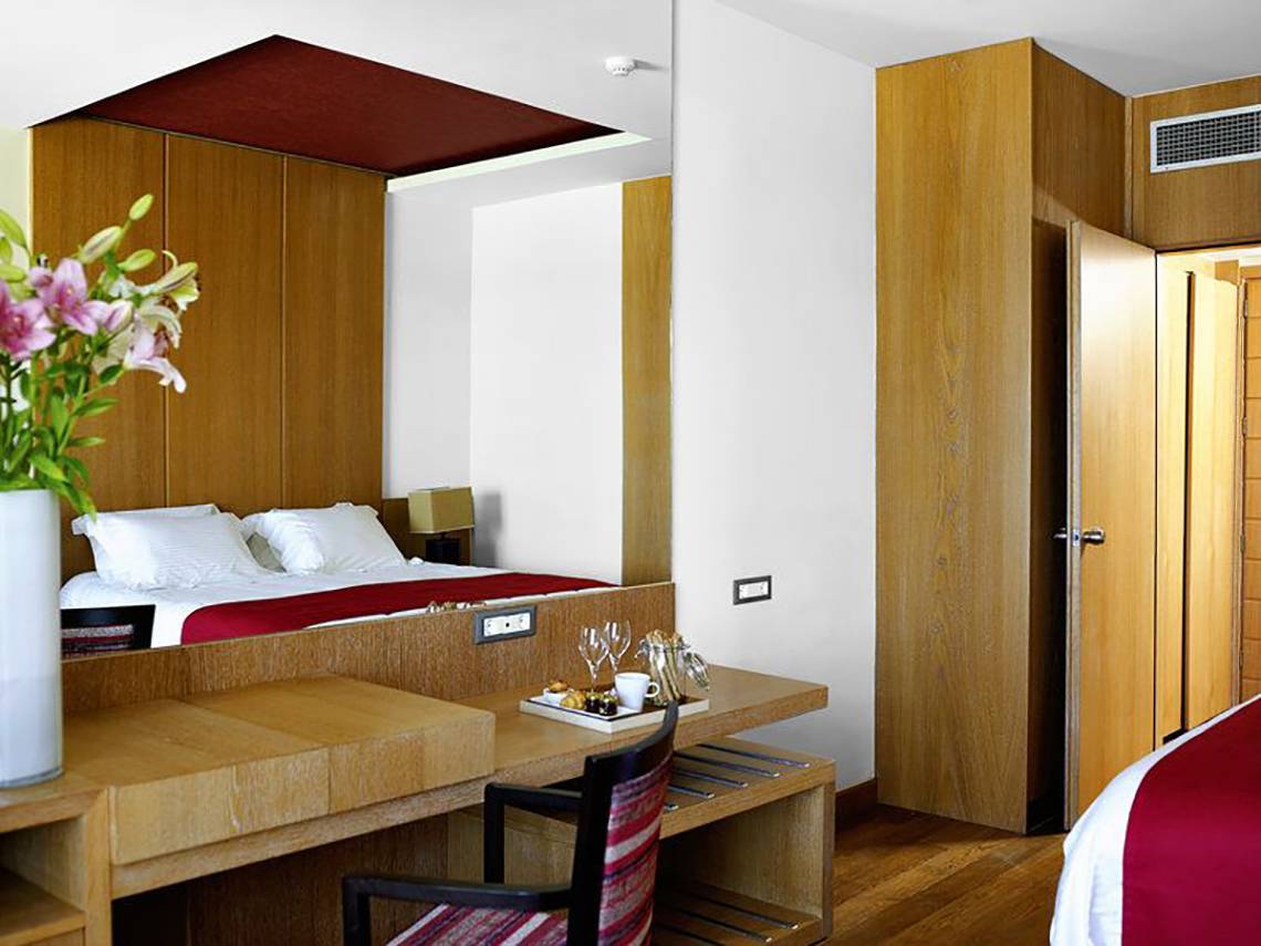 Zimmer im Atlantica Kalliston Resort mit großem Bett, Tisch und Spiegel