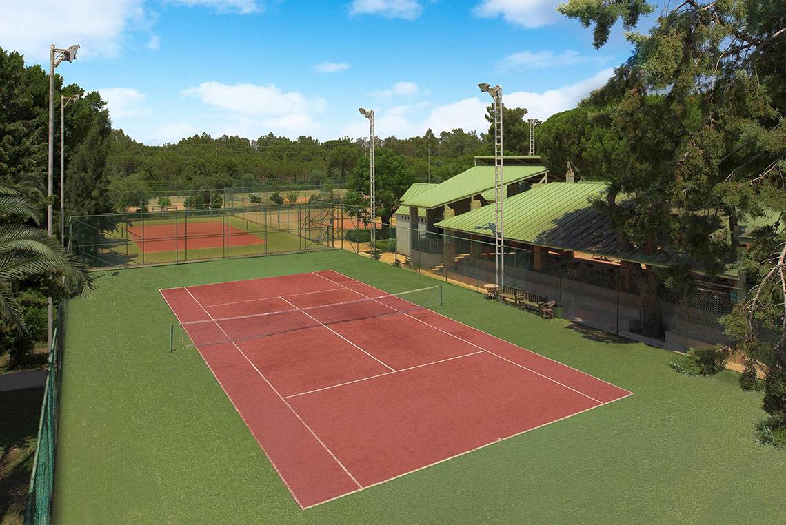 Tennisplatz im Megasaray Club Belek mit grünen Rasenflächen und roten Spielfeldern.