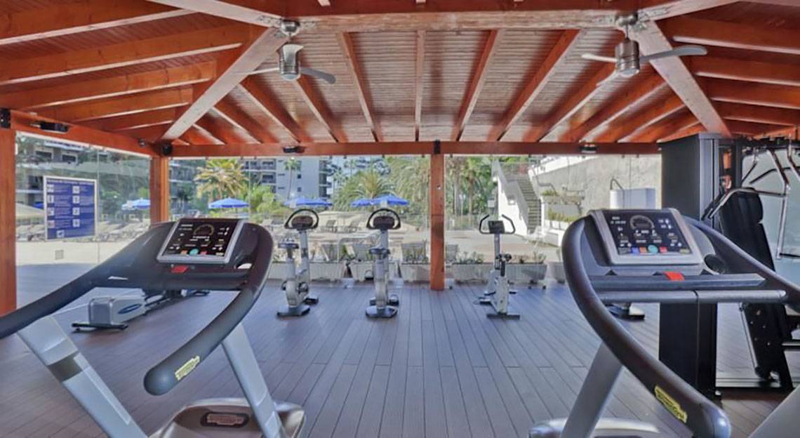 Fitnesscenter im Barcelo Margaritas Hotel mit Laufbändern und anderen Geräten unter einem Pavillon.