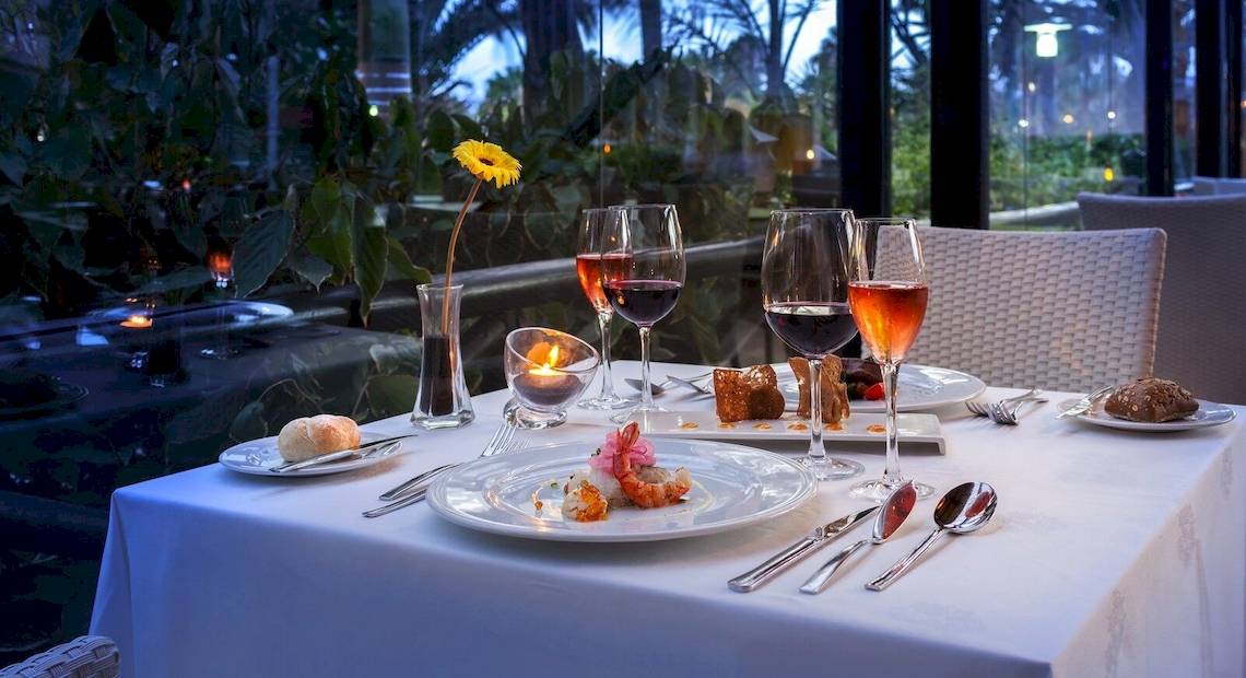 Gedeckter Tisch im Barcelo Fuerteventura Mar mit Gläsern, Tellern und Speisen.