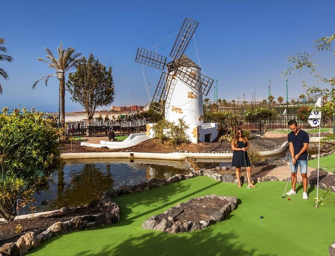 Golfplatz mit einem Paar, das vor einer Mühle spielt, im Freien.