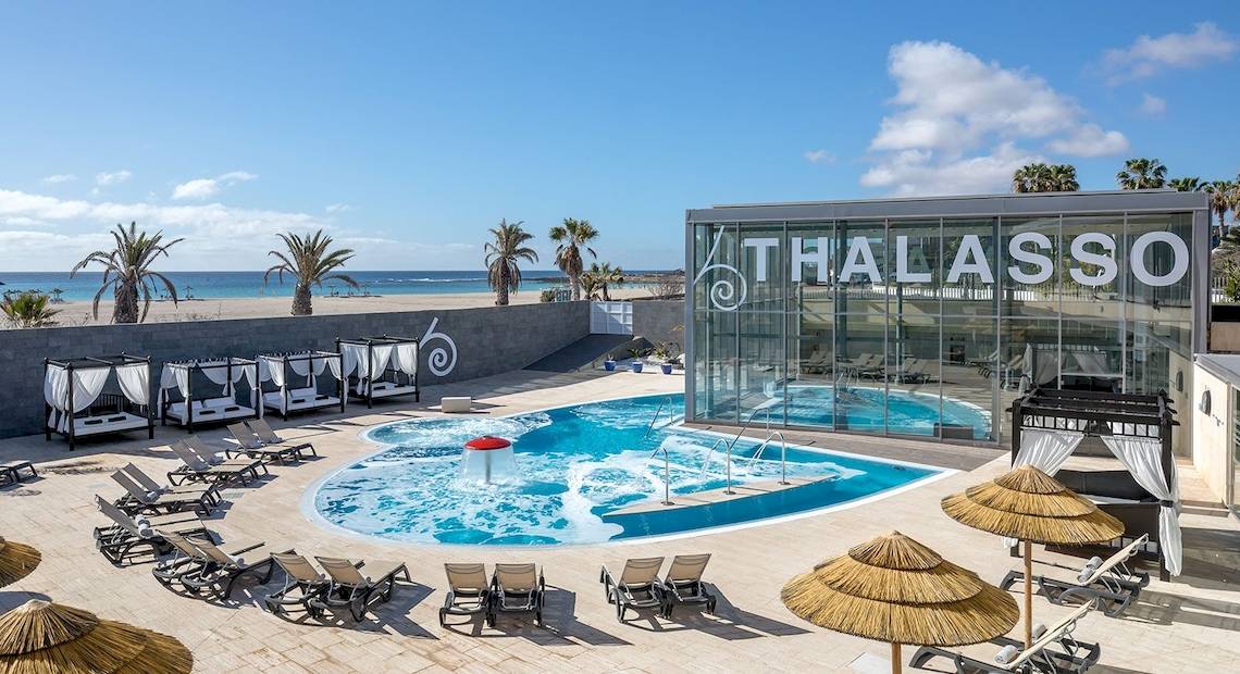 Außenpool des Barcelo Fuerteventura Mar Thalasso Hotel mit Loungeliegen und Sonnenschirmen.