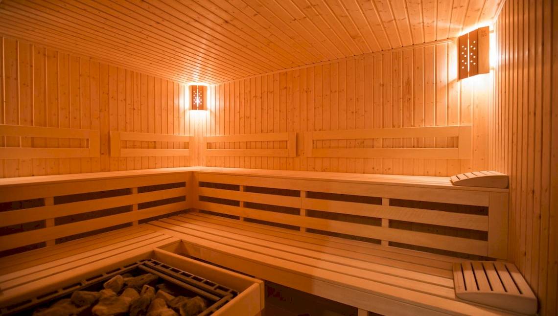 Innenansicht der Sauna im Marina Grand Beach Hotel mit Holzwänden und Bänken.