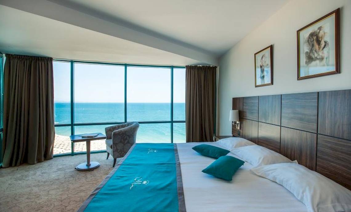 Zimmer im Marina Grand Beach Hotel mit Blick auf das Meer und zwei Betten
