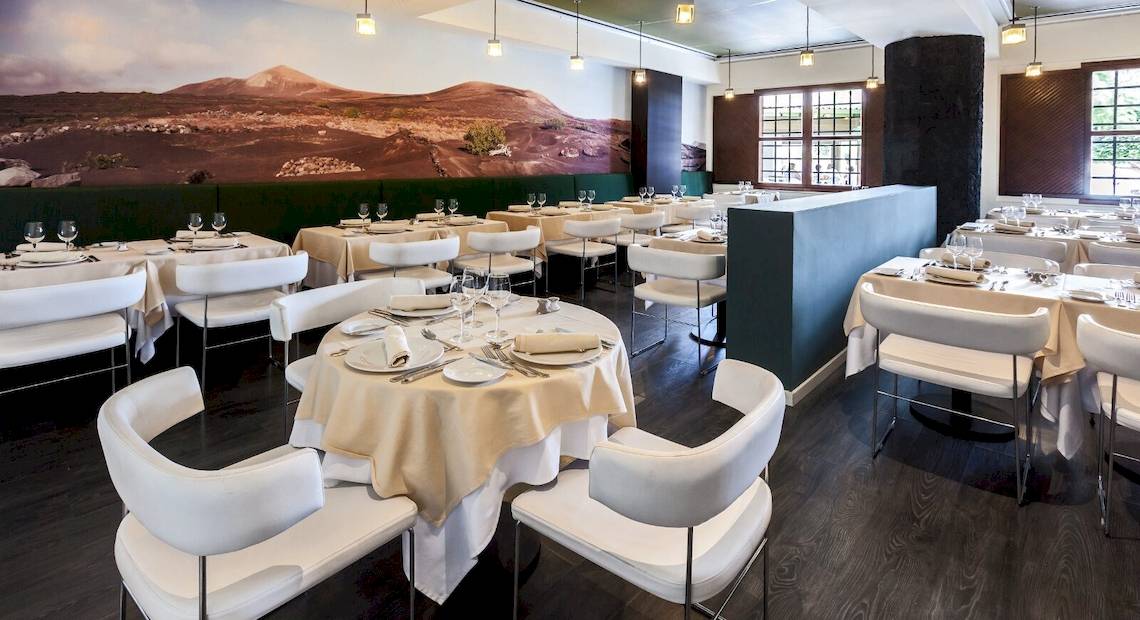 Innenbereich des Restaurants im Barcelo Lanzarote Active Resort mit gedeckten Tischen und Stühlen.